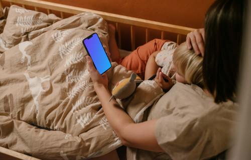 Person's hand holding an iPhone mockup