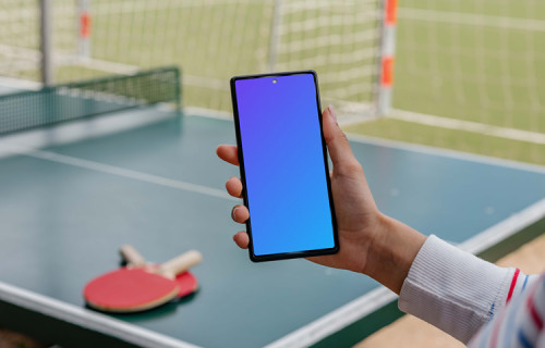 Ping-pong player holding a phone mockup