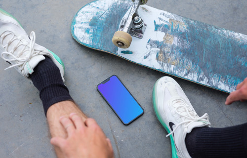 Skateboarder sitting next to an iPhone 13 mockup