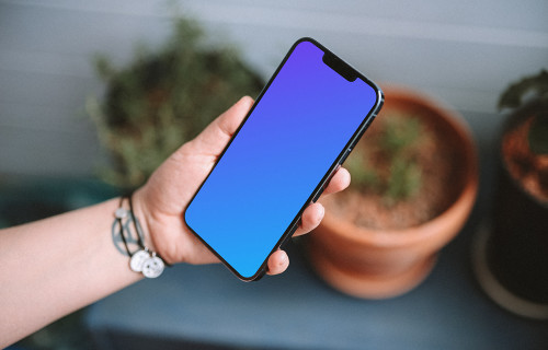User holding an iPhone 13 mockup