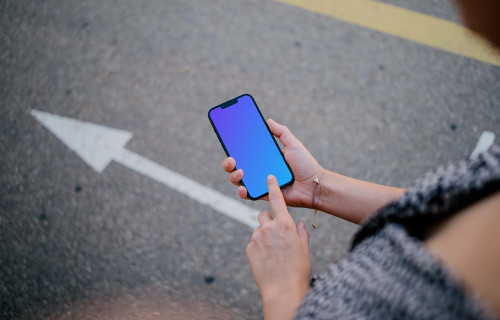 Woman hand pointing on an iPhone 13 mockup