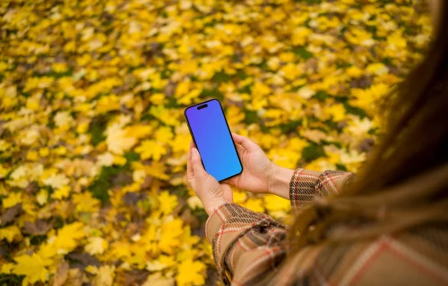 Woman hands holding an iPhone 14 Pro in autumn theme mockup