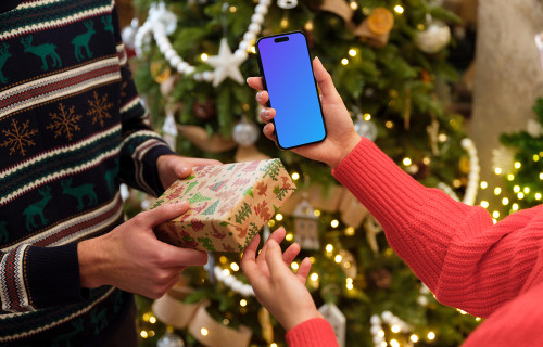 Woman holding a phone and Christmas gift mockup