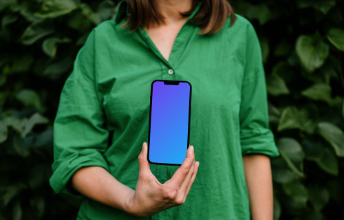 Woman holding an iPhone 13 mockup in green theme