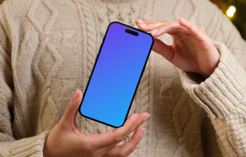 Woman holding an iPhone 14 Pro mockup next to the Christmas tree