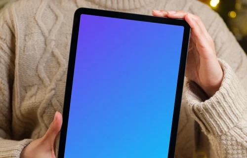 Woman holding iPad mockup next to the Christmas tree