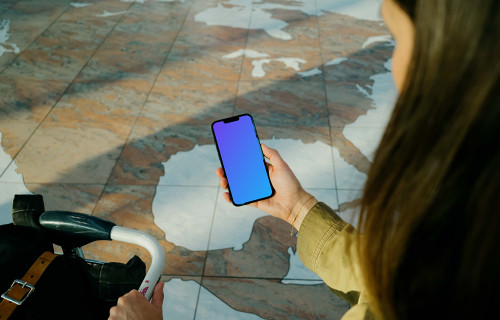 Woman holding iPhone 13 mockup at the airport