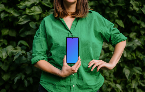 Woman in green environment holding a phone mockup