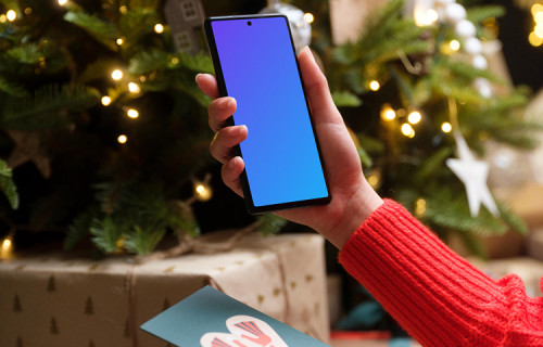 Woman in red sweater holding smartphone and gift card