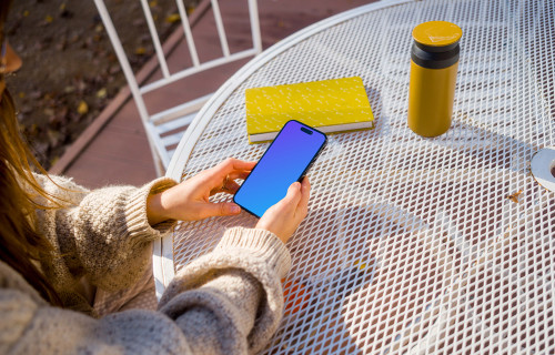 Woman in sweater holding an iPhone mockup