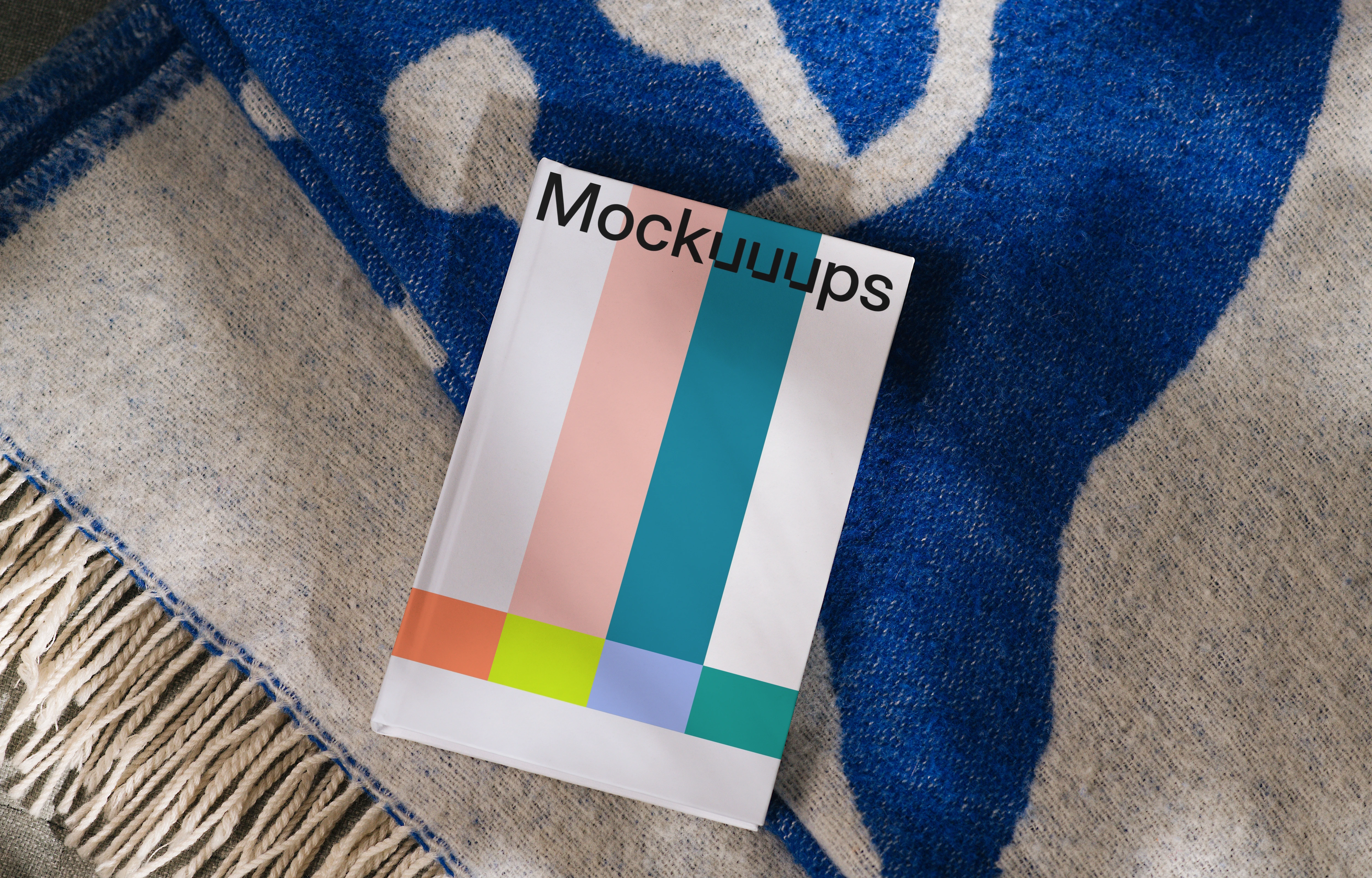 Book mockup on a cozy blue and beige blanket