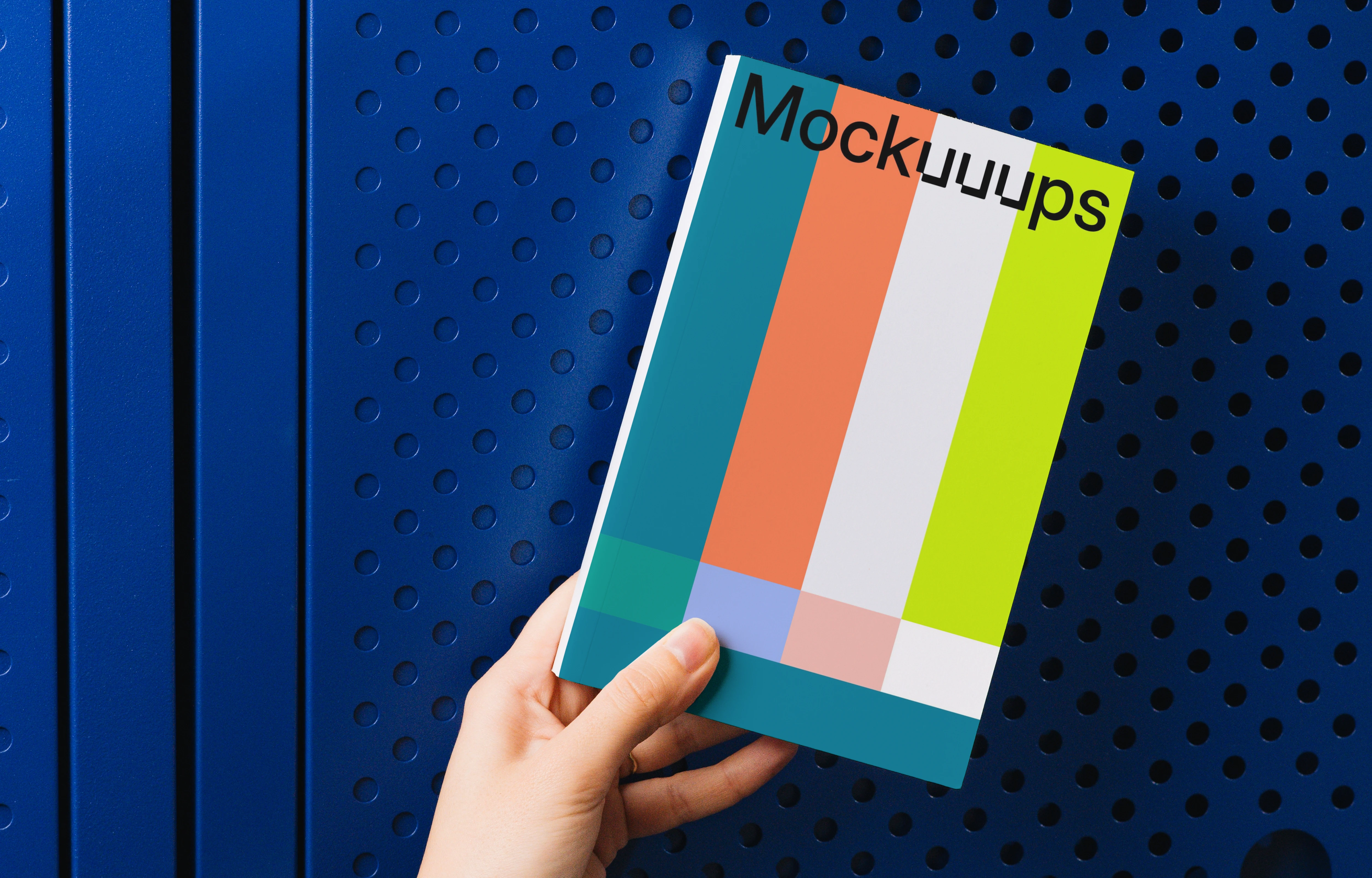 Hand holding a book mockup against a blue background