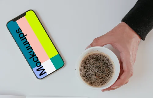 Minimal iPhone mockup on a table with a cup of coffee by the side