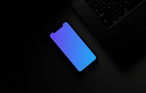 Night iPhone mockup on a table beside a keyboard