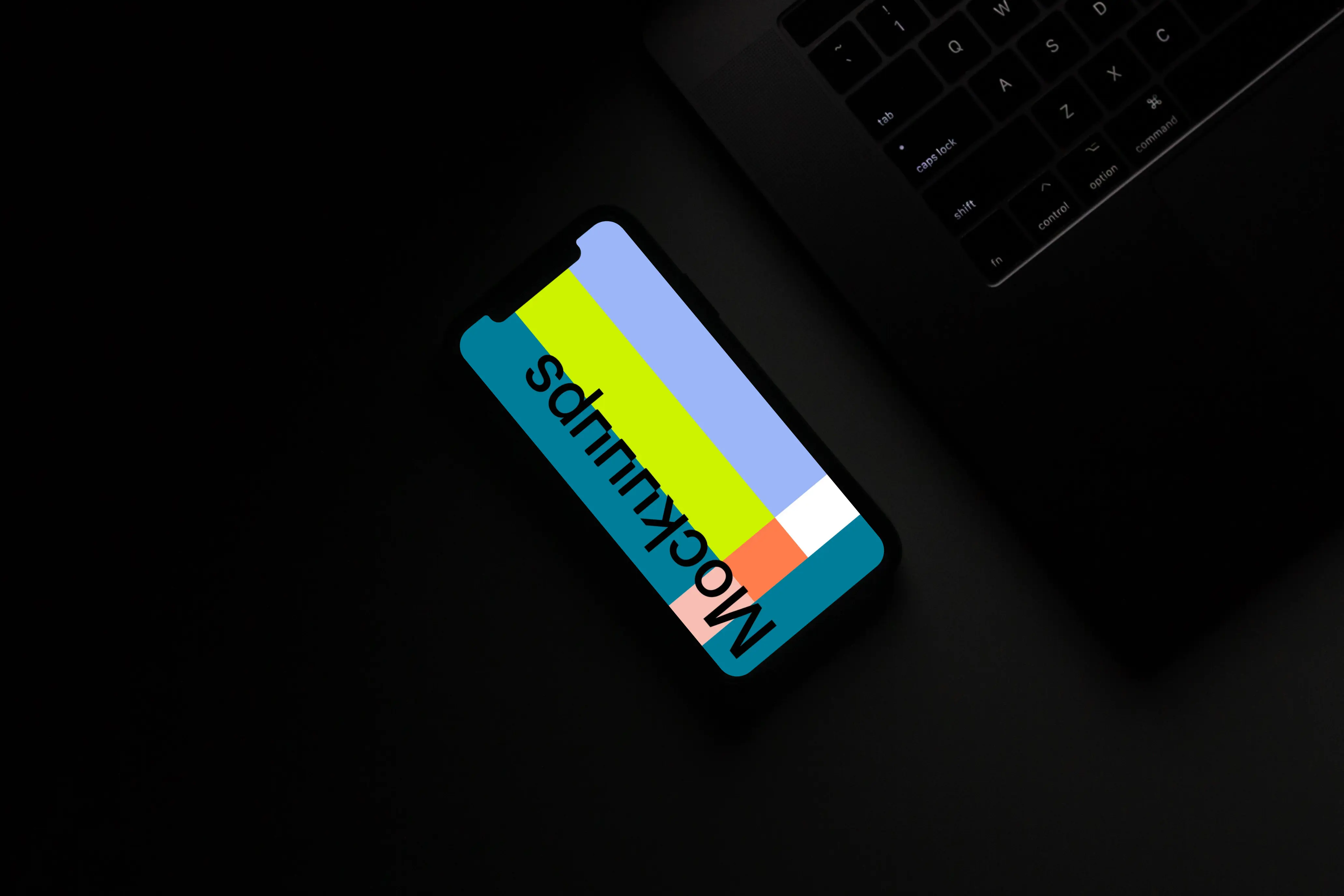 Night iPhone mockup on a table beside a keyboard