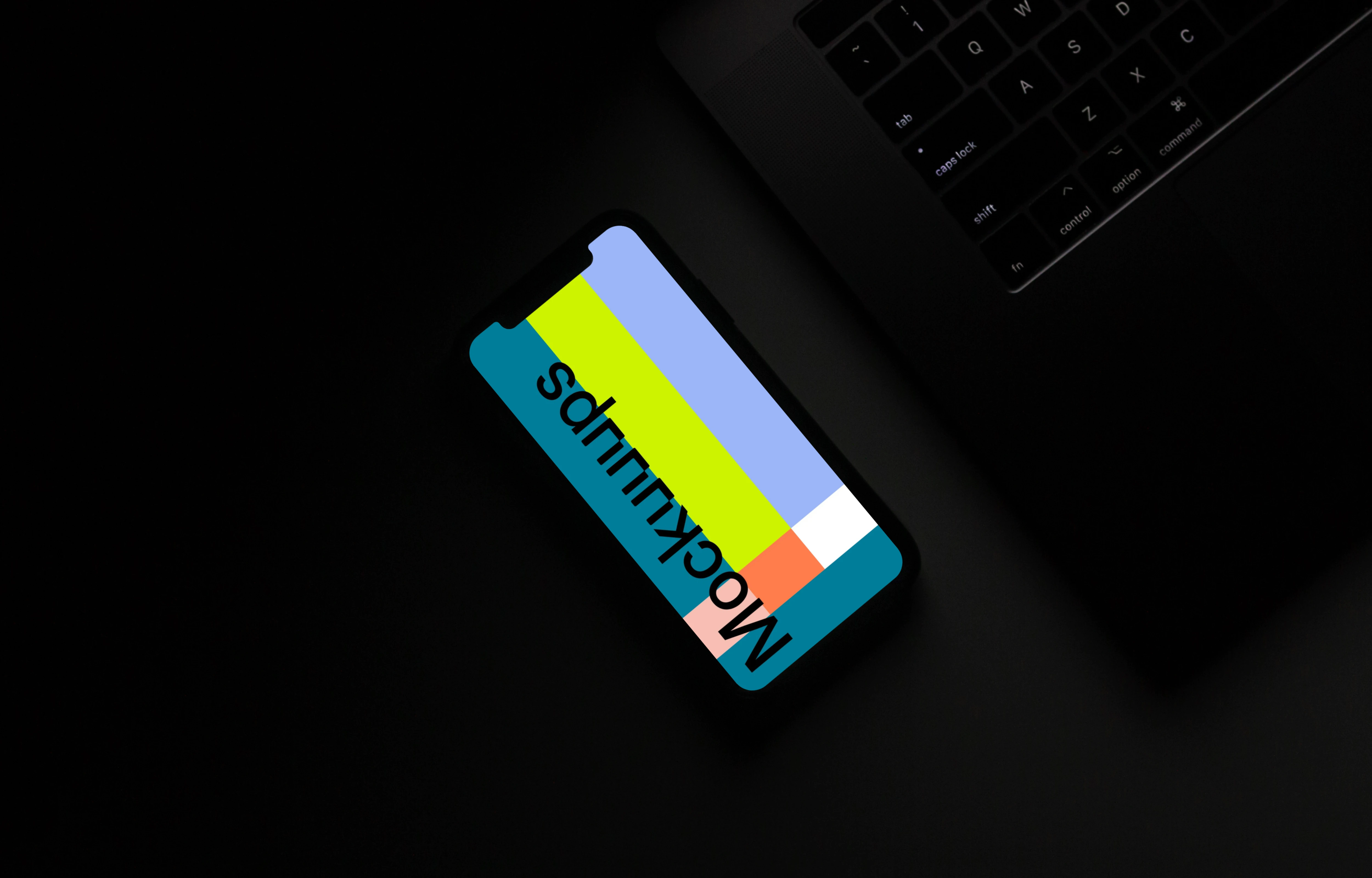 Night iPhone mockup on a table beside a keyboard