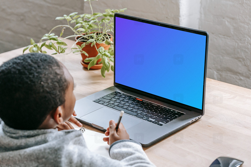 Kid studying with a gray MacBook Pro mockup