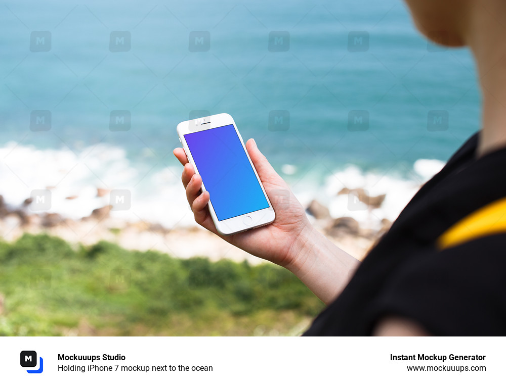 Holding iPhone 7 mockup next to the ocean