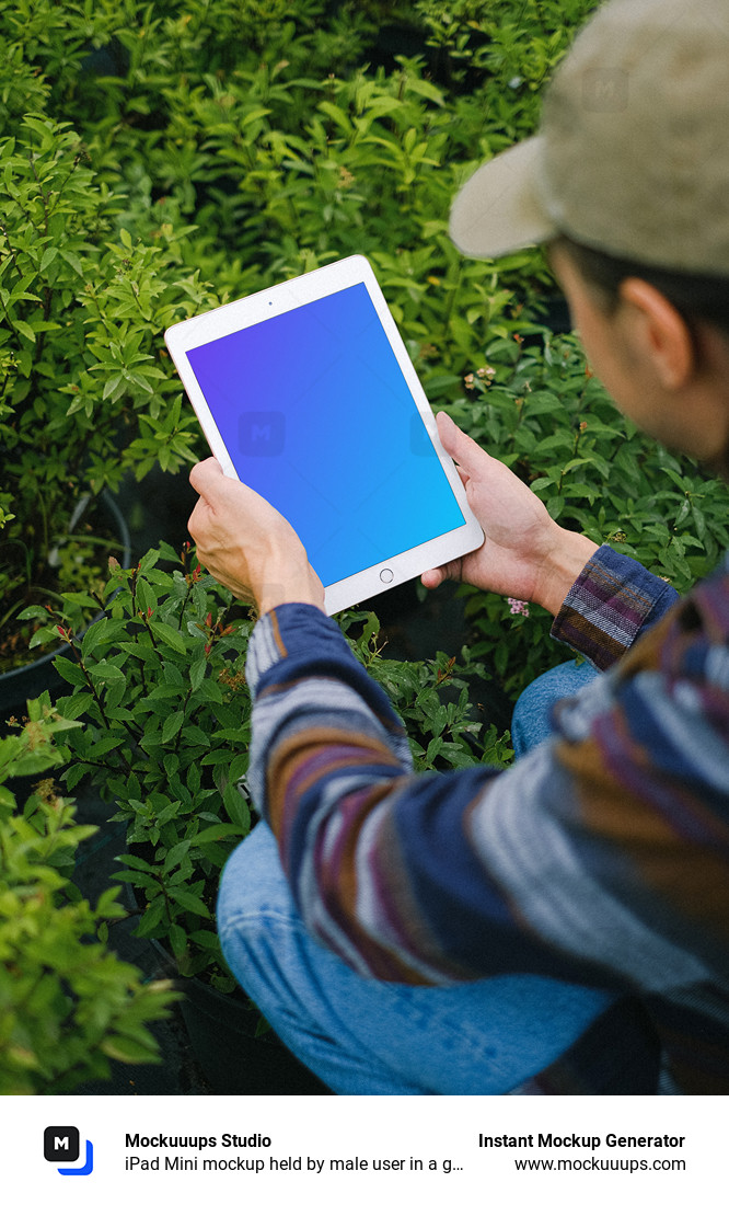 iPad Mini mockup held by male user in a garden.