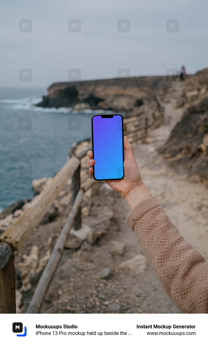 iPhone 13 Pro mockup held up beside the ocean