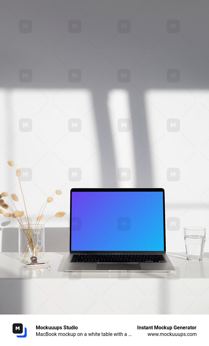 MacBook mockup on a white table with a glass of water at the side