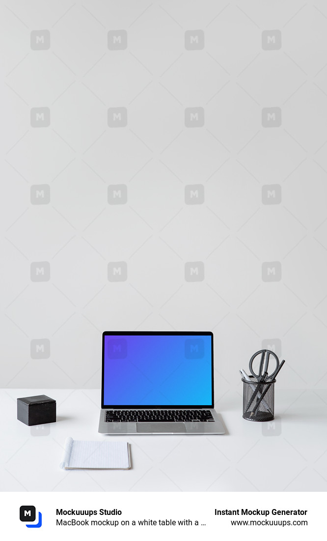 MacBook mockup on a white table with a notebook in front of it