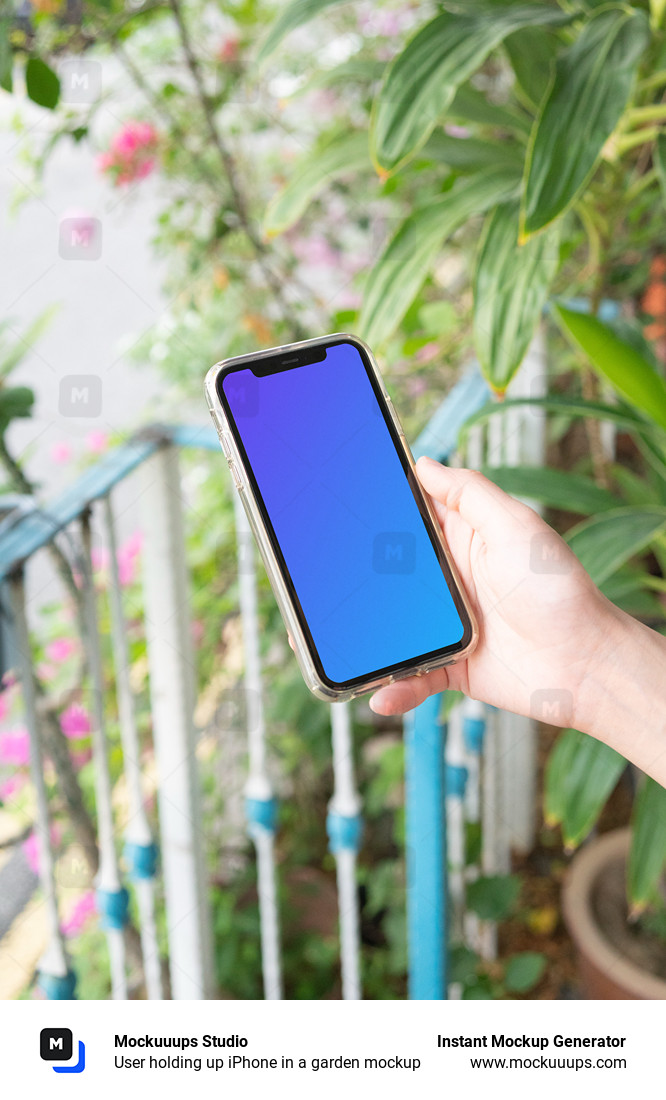 User holding up iPhone in a garden mockup