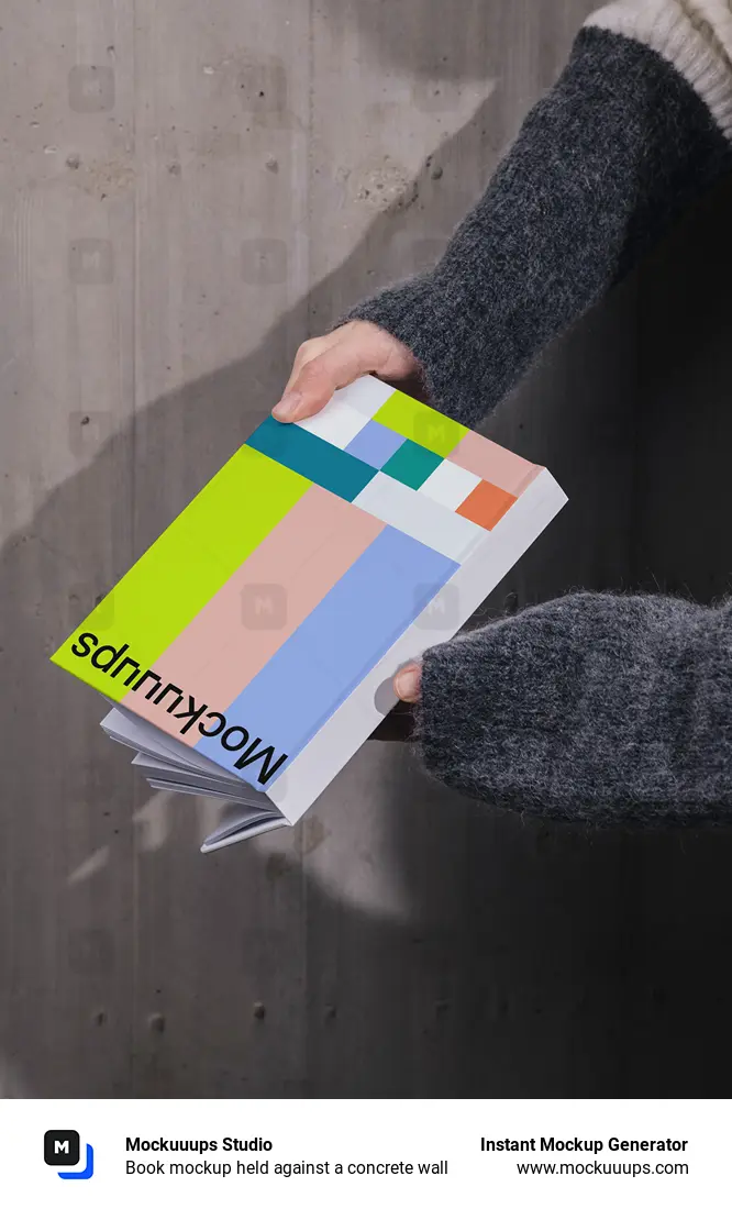 Book mockup held against a concrete wall