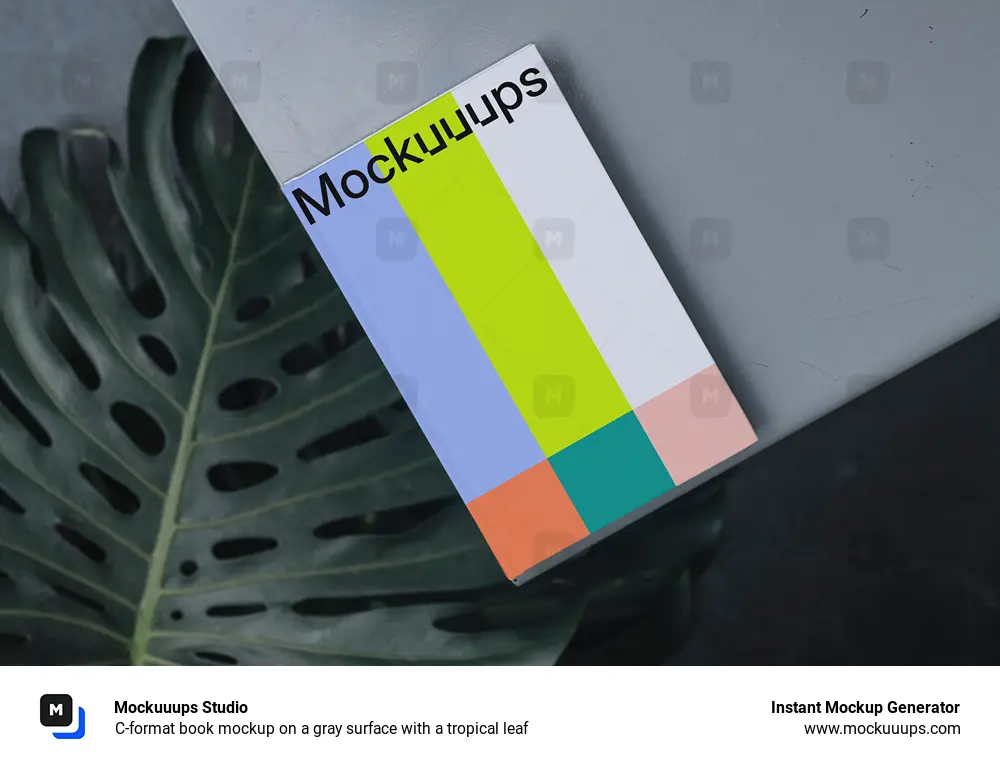 C-format book mockup on a gray surface with a tropical leaf