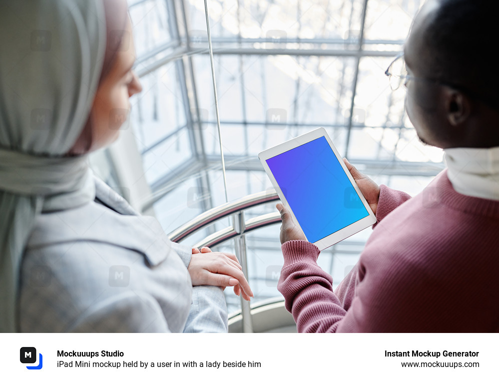 iPad Mini mockup held by a user in with a lady beside him