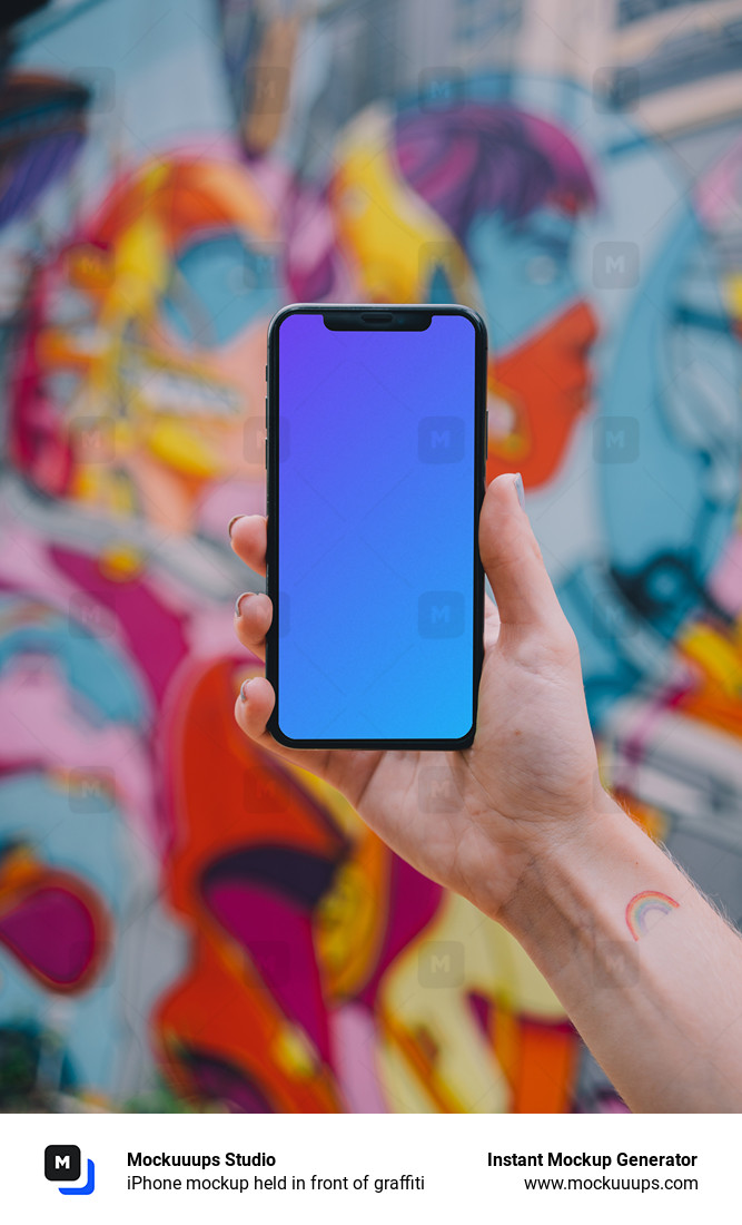 iPhone mockup held in front of graffiti 