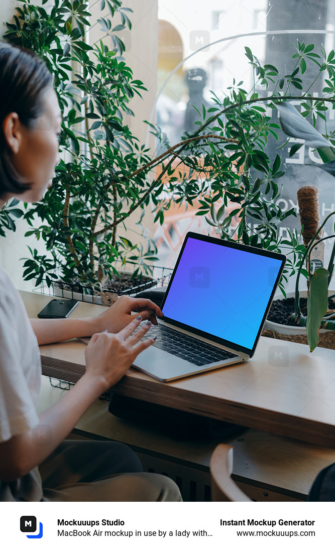 MacBook Air mockup in use by a lady with a lot of plants in the background