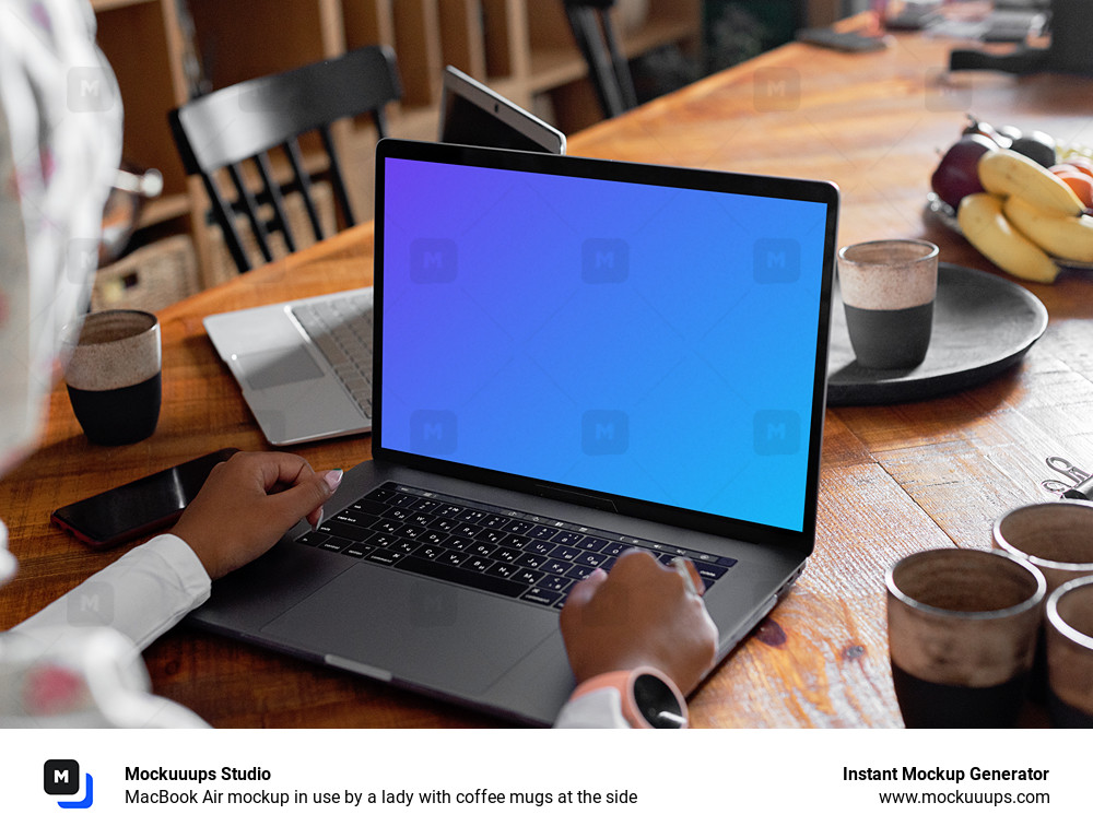 MacBook Air mockup in use by a lady with coffee mugs at the side 