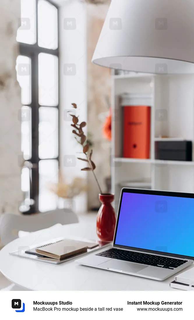 MacBook Pro mockup beside a tall red vase