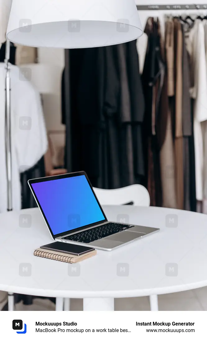 MacBook Pro mockup on a work table beside phone and notepad