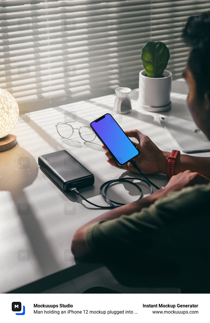 Man holding an iPhone 12 mockup plugged into a power bank