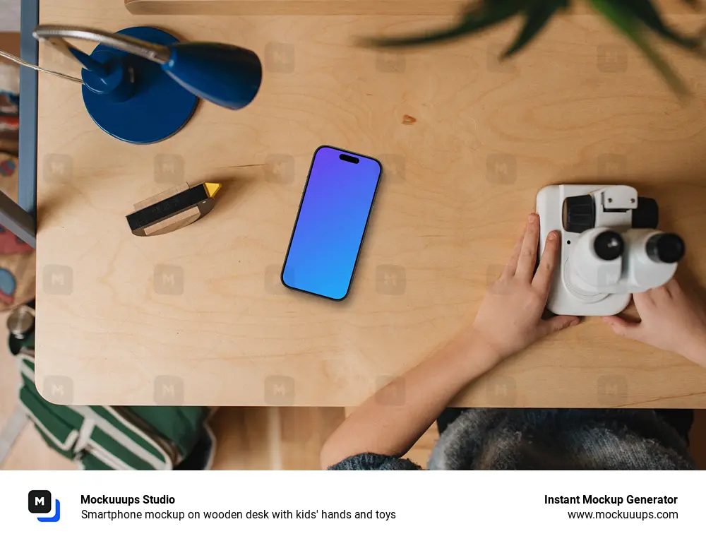 Smartphone mockup on wooden desk with kids' hands and toys