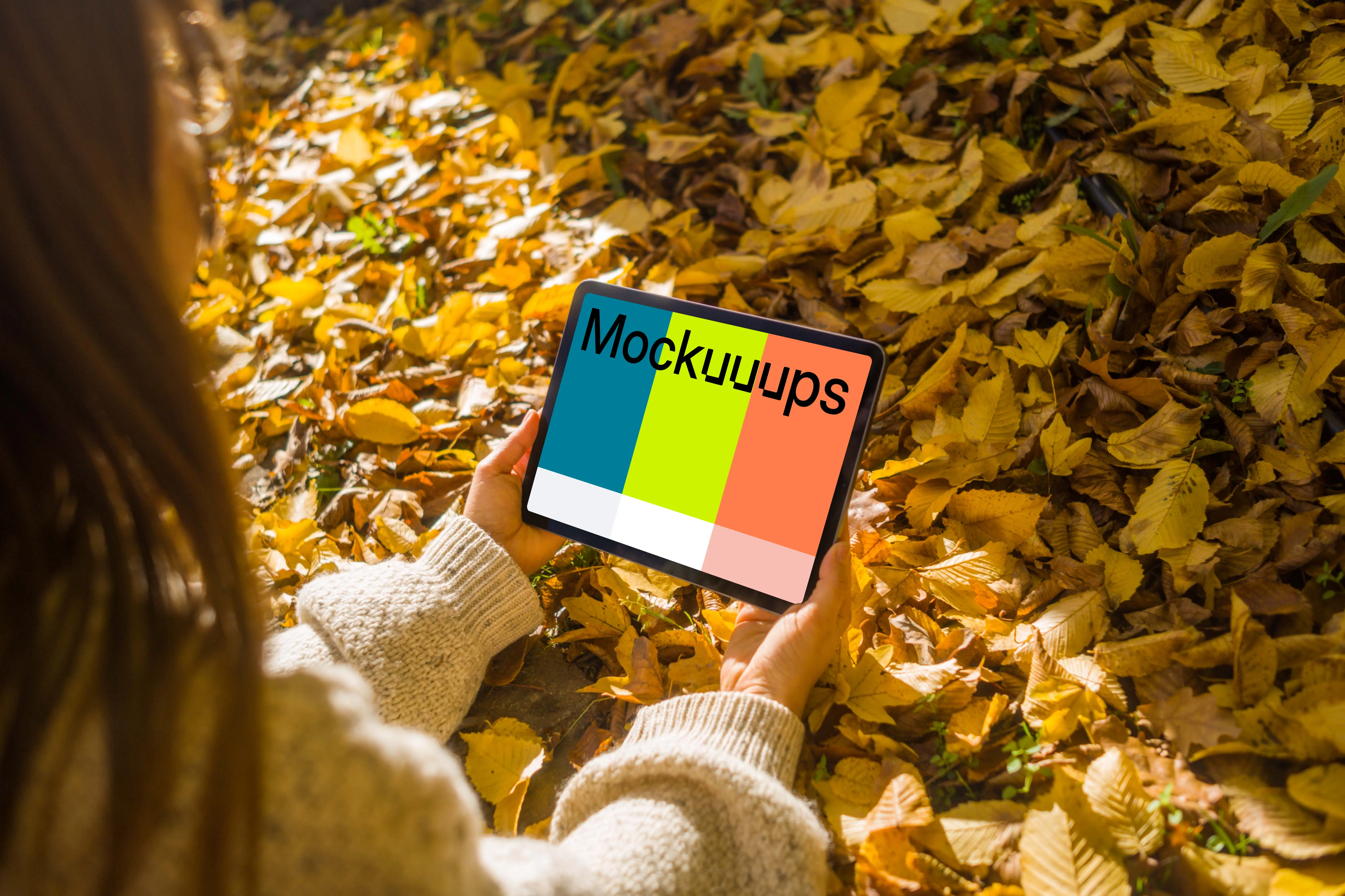 Female hands holding an iPad Air in the leaves mockup