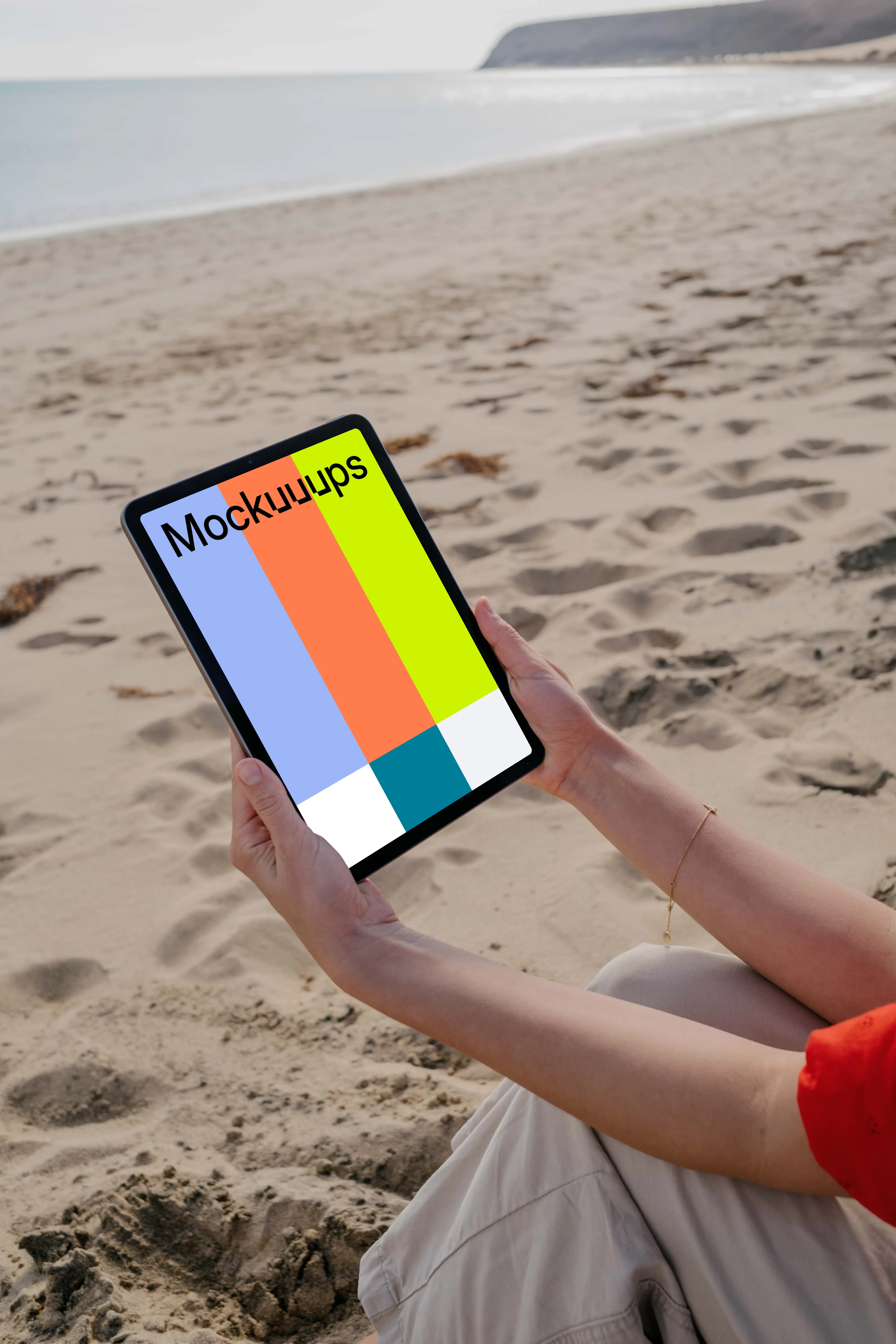 iPad Air mockup held by a user at the beach
