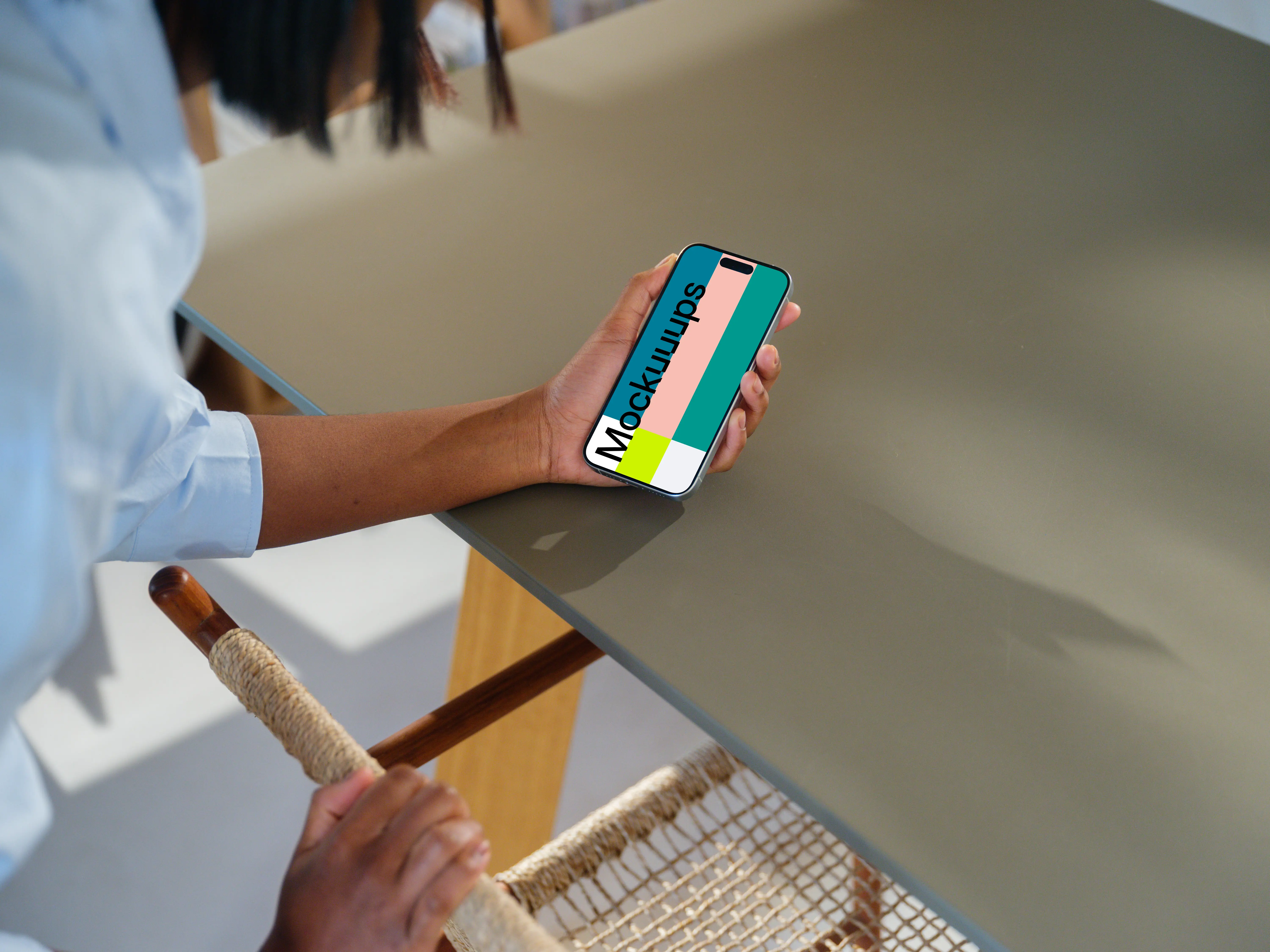 iPhone 15 Pro mockup in a woman's hand at a modern desk
