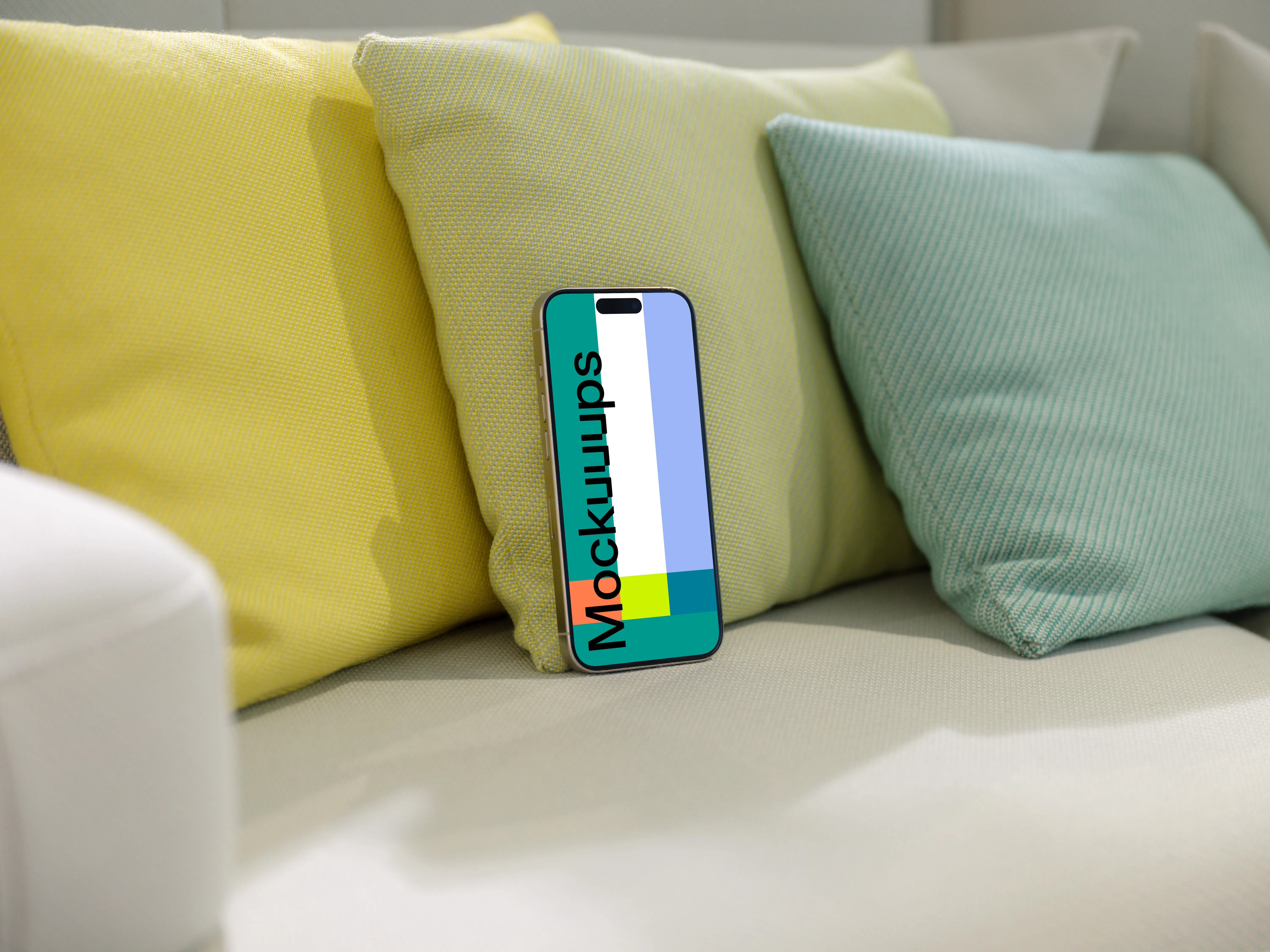 iPhone 15 Pro mockup on a cozy sofa with colorful cushions