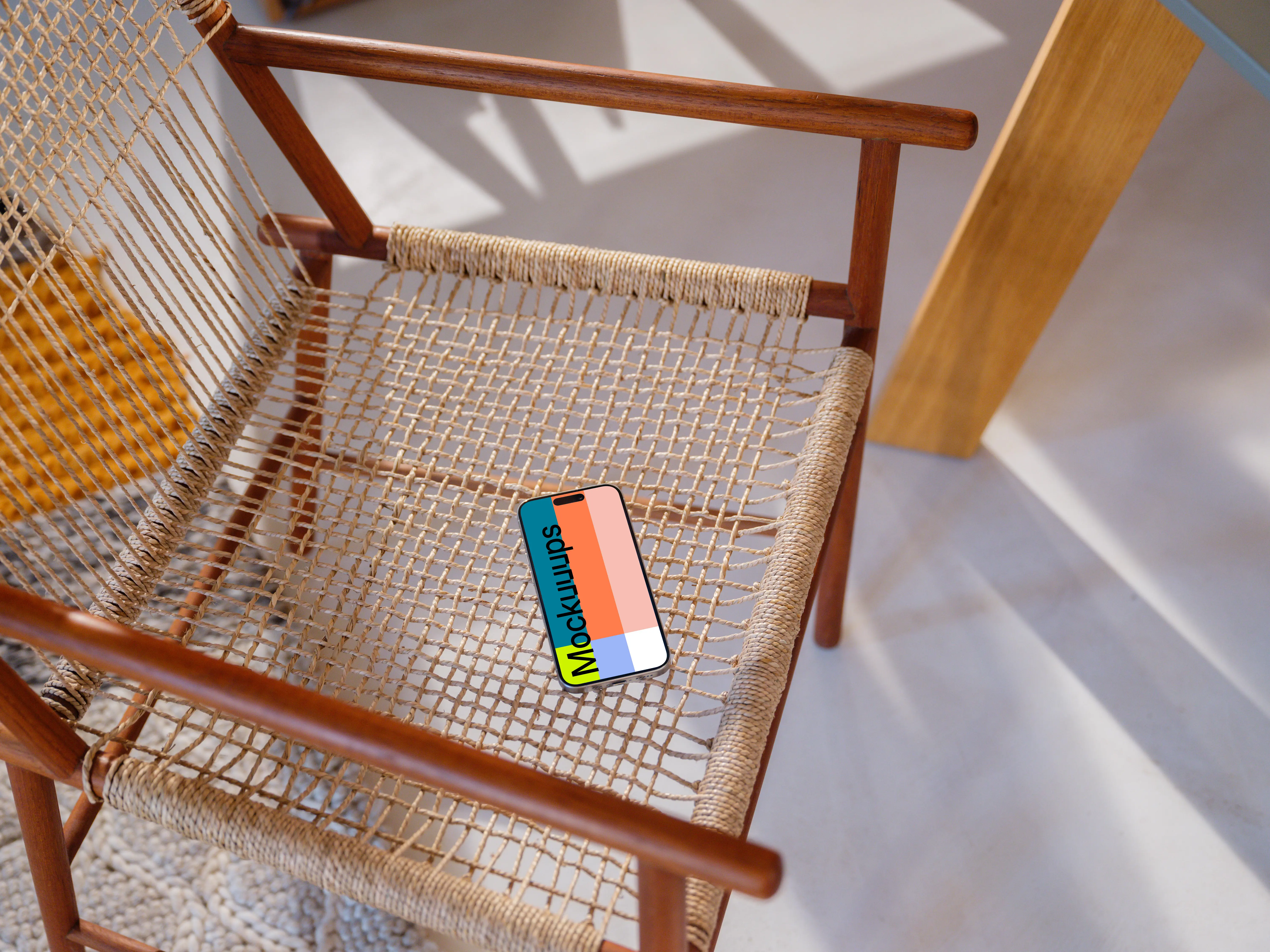 iPhone 15 Pro mockup on a modern woven chair