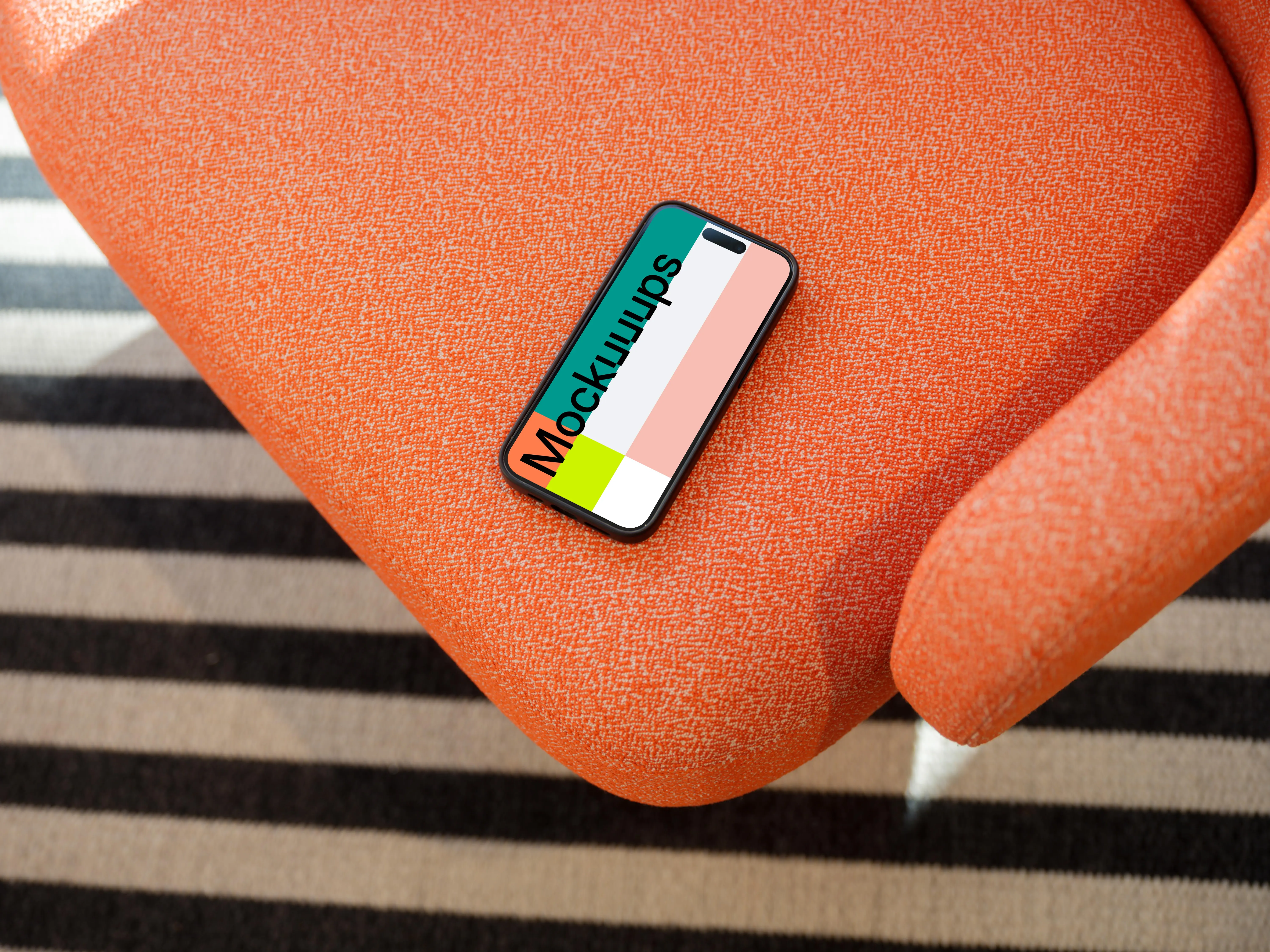 iPhone 15 Pro mockup on a vibrant orange armchair