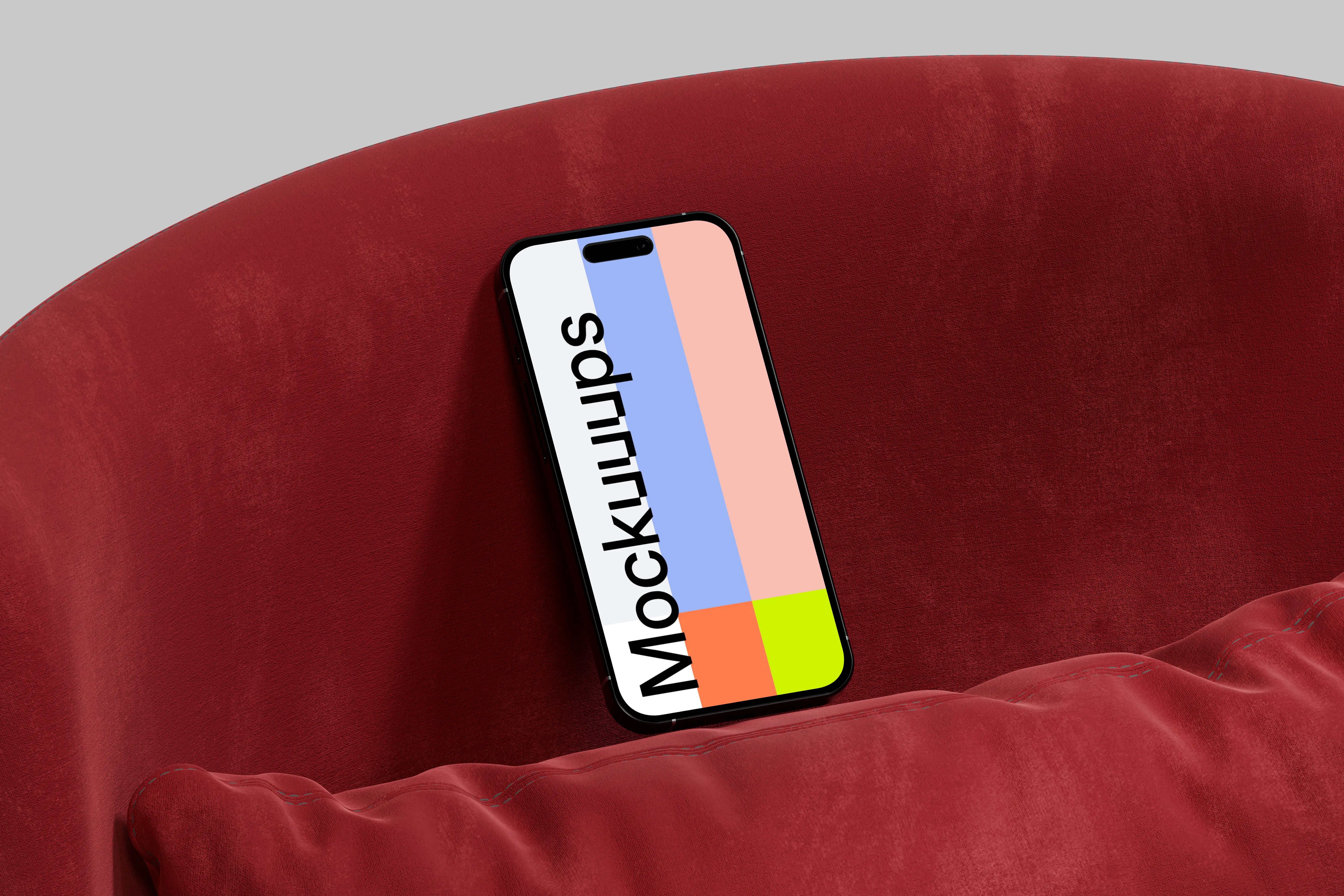 iPhone 16 mockup against a red cushion