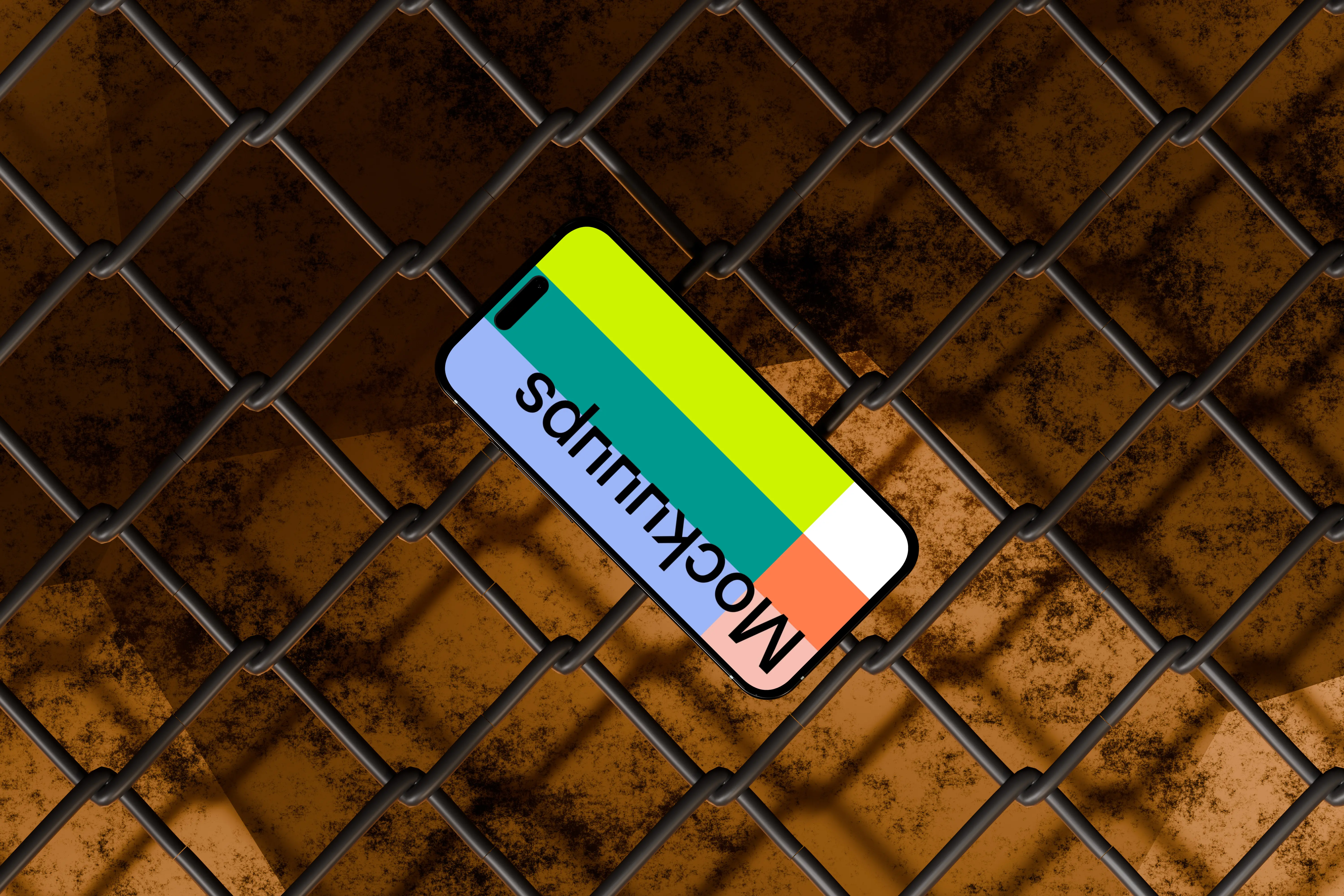 iPhone 16 Mockup Against Industrial Chain-Link Fence