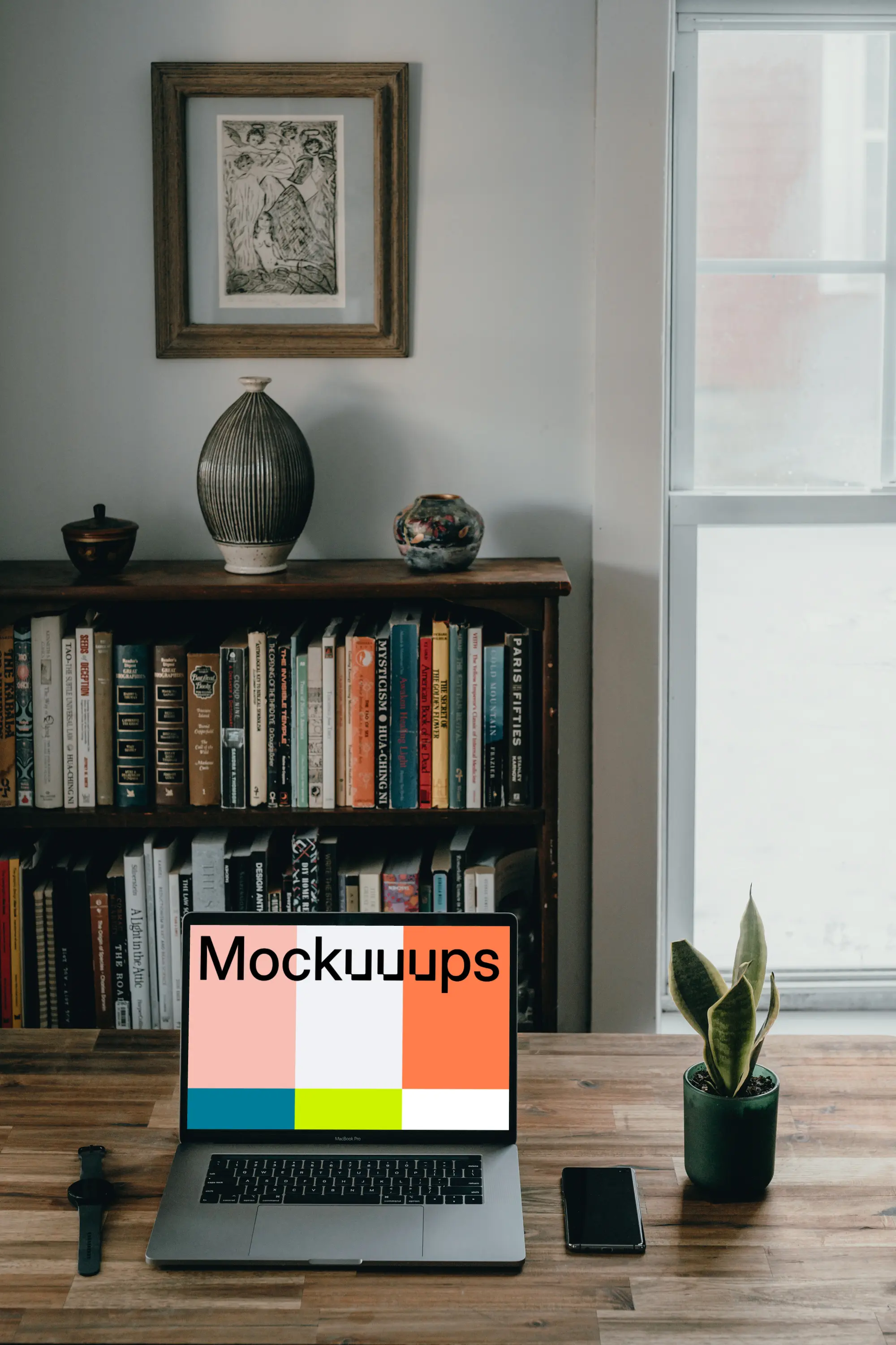 MacBook Pro mockup beside a smartphone and potted plant