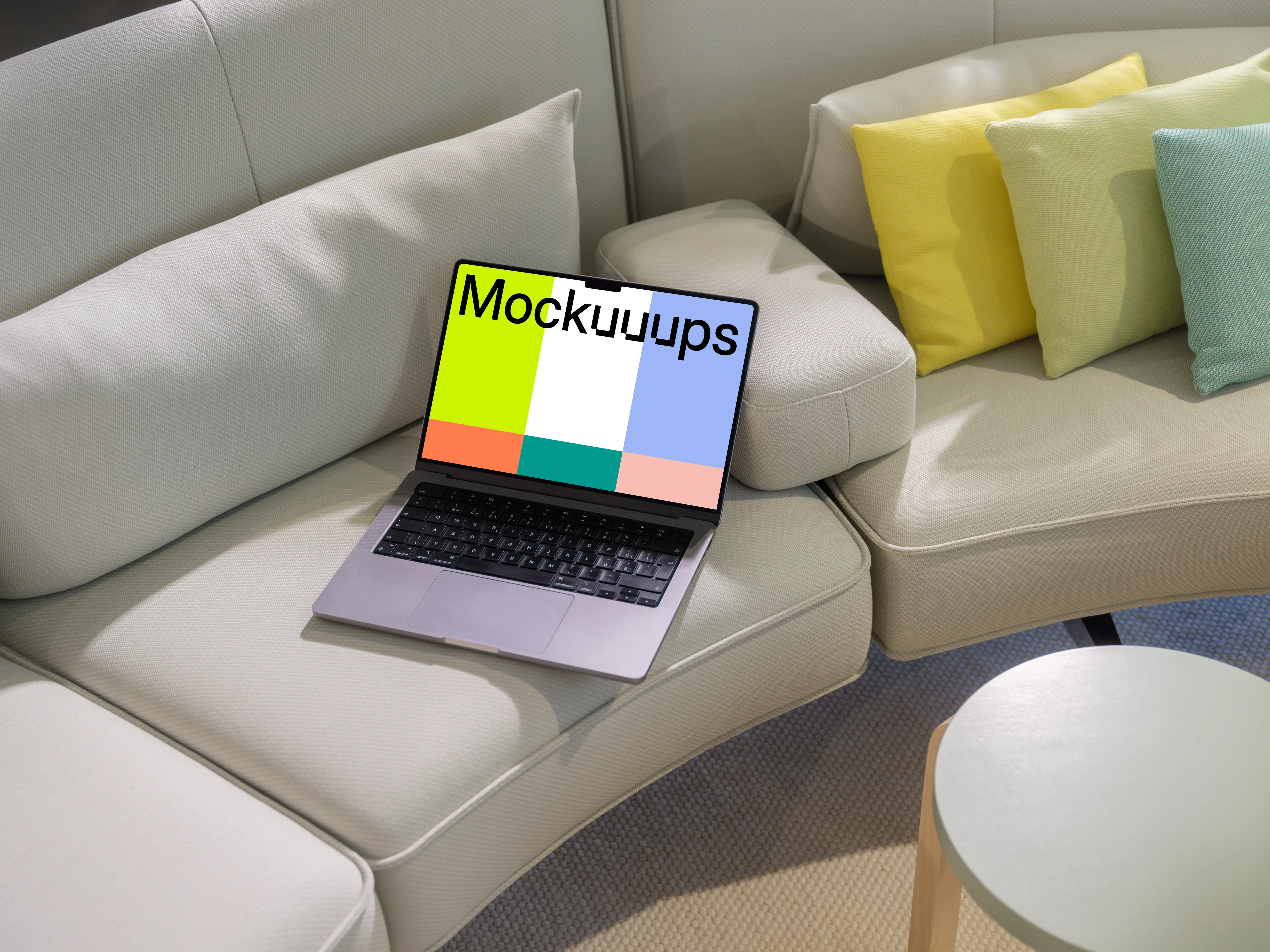 MacBook Pro mockup on a modern beige sofa with colorful pillows