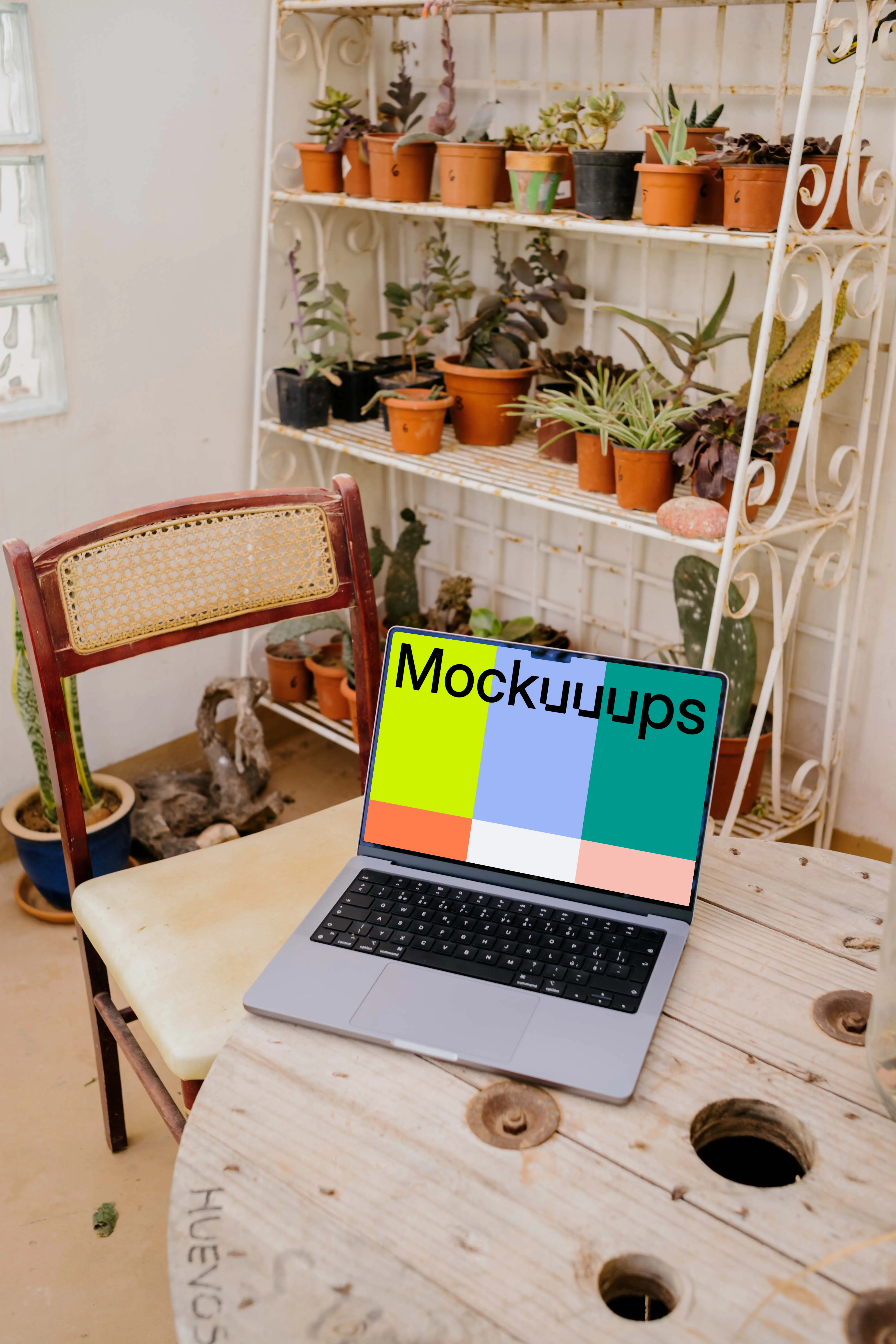 MacBook Pro mockup on a table next to a chair