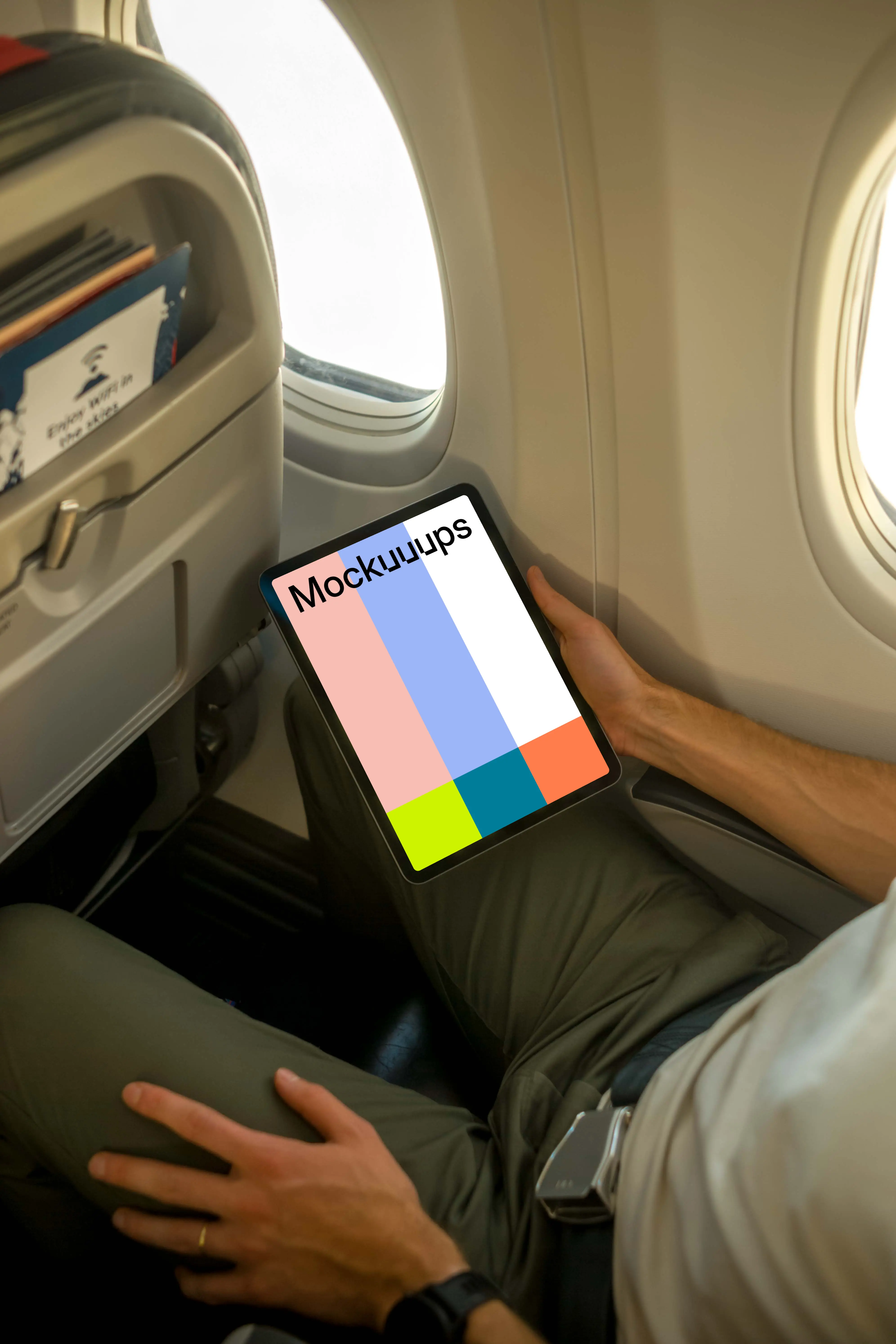 Man using iPad Air mockup while sitting in airplane