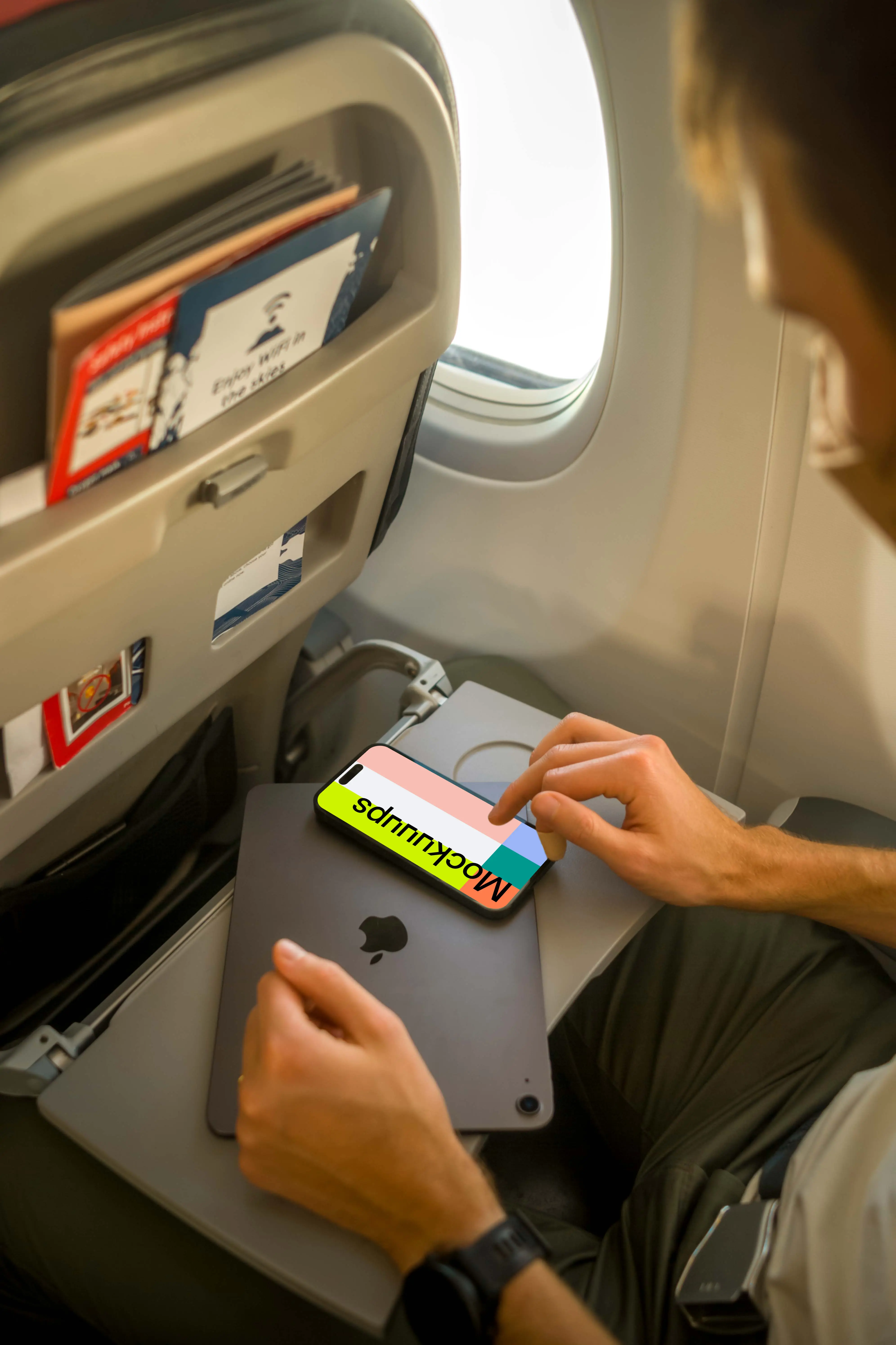 Man using iPhone 14 Pro mockup while sitting in airplane